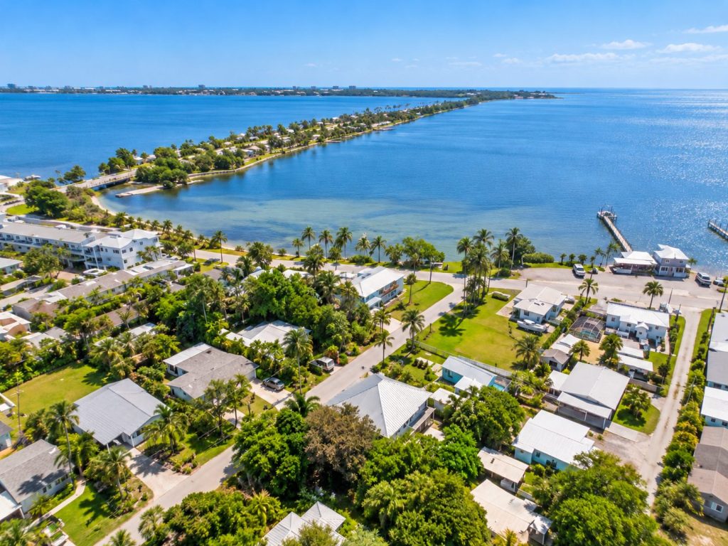 Aerial view of a residential street with metal-roof homes near the Indian River Lagoon waterfront