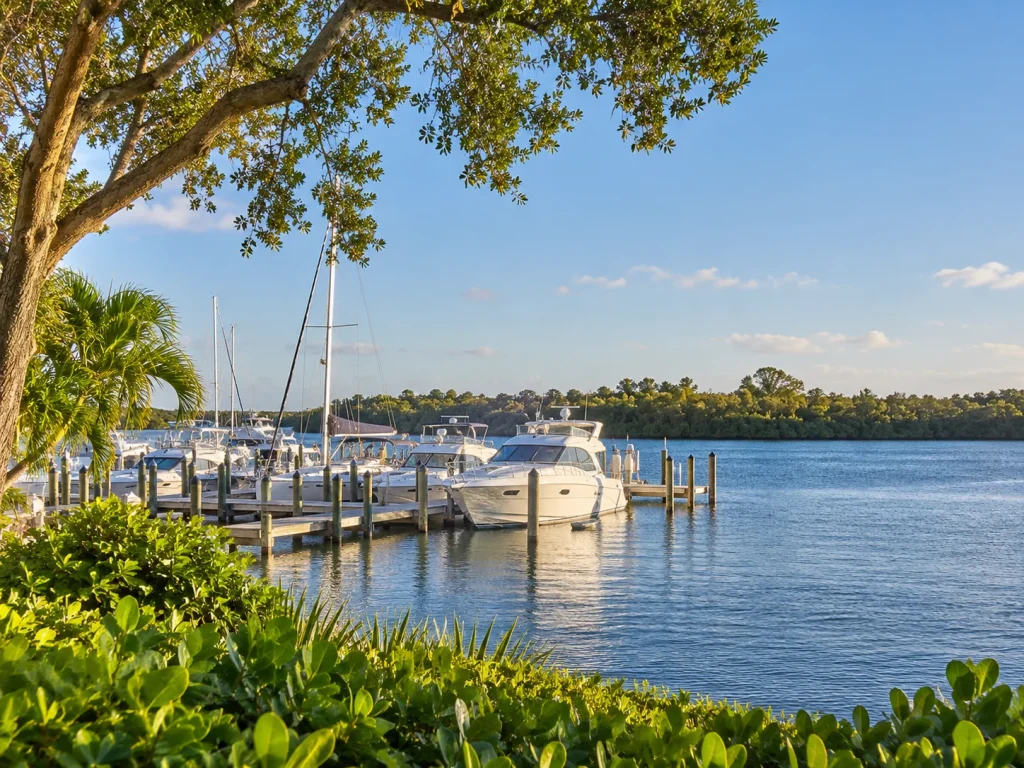 Private marina with yachts and sailboats docked on a riverfront